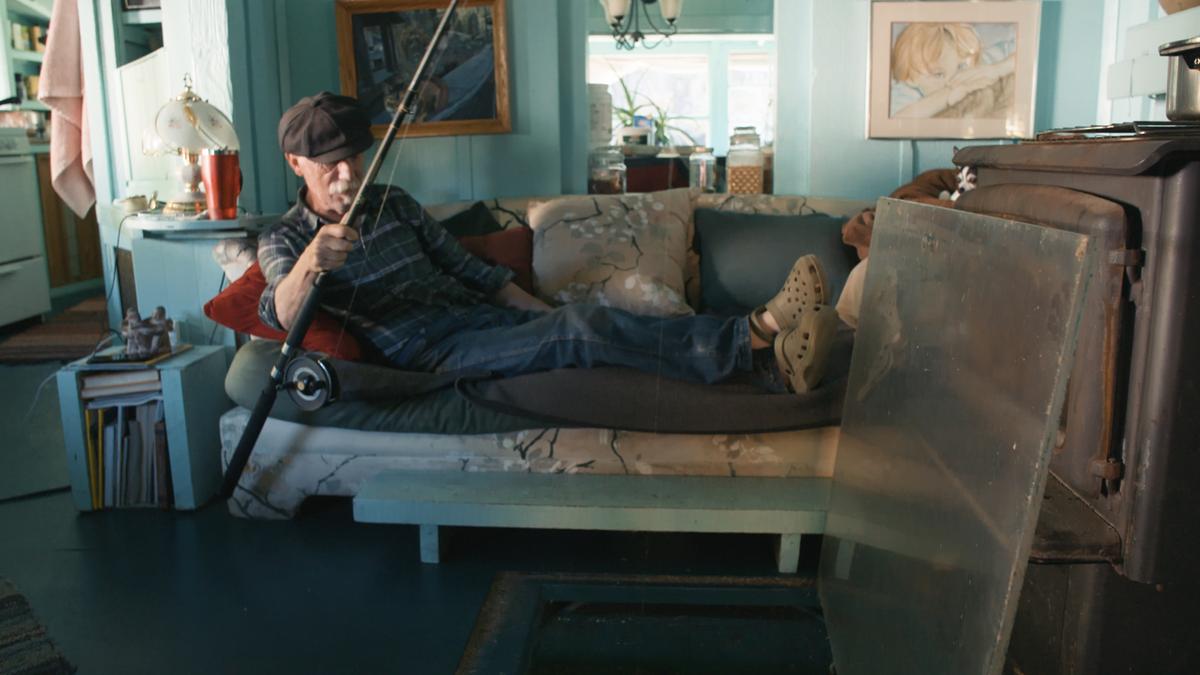 Adams is able to fish from the comfort of his couch due to a piece of Plexiglass in their living room. (Courtesy of Great Big Story)