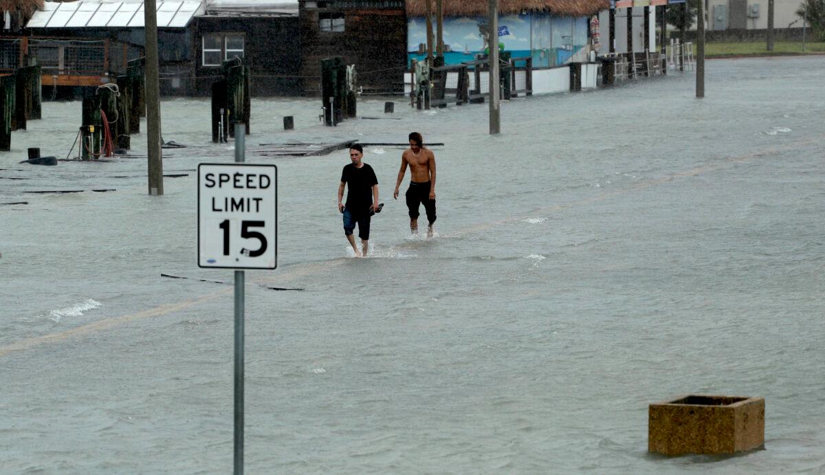 Two men walk on a flooded road as Hurricane Hanna makes landfall, in Corpus Christi, Texas, on July 25, 2020. (Eric Gay/AP Photo)