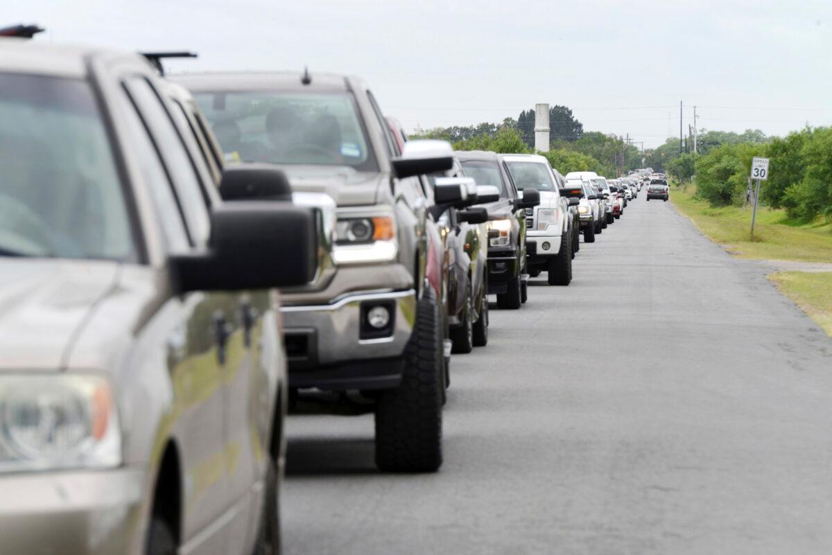 Hundreds of vehicles form a line as Brownsville residents wait for sandbags at Anastacio Guillen Precinct 1 Cameron County Public Works Building along Browne Avenue as South Texas prepare for torrential rainfall due to Hurricane Hanna, on July 25, 2020. (Miguel Roberts/The Brownsville Herald via AP)