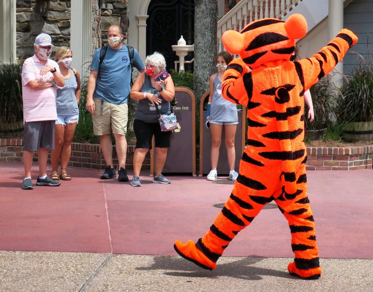 Tigger entertains guests wearing masks as required to attend the official reopening day of the Magic Kingdom at Walt Disney World in Lake Buena Vista, Fla., on July 11, 2020. (Joe Burbank/Orlando Sentinel via AP)