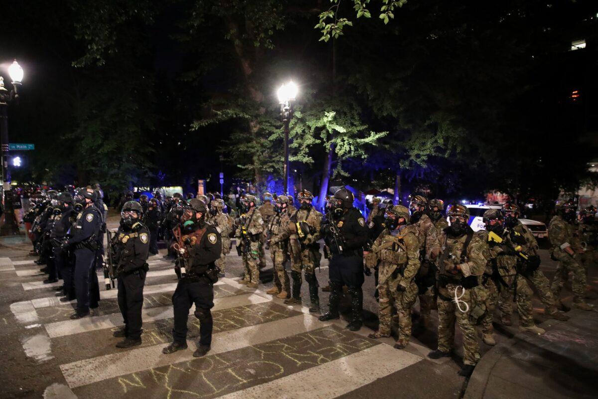 Federal law enforcement officers block off a street after clearing rioters from outside the Mark O. Hatfield Courthouse in Portland, Ore., on July 27, 2020. (Caitlin Ochs/Reuters)