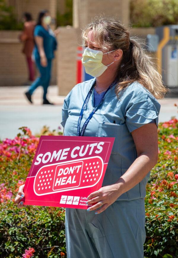 A nurse holds a sign at a protest over staffing and safety due to the COVID-19 pandemic at the Ronald Reagan UCLA Medical Center in Los Angeles, Calif., on July 29, 2020. (John Fredricks/The Epoch Times)