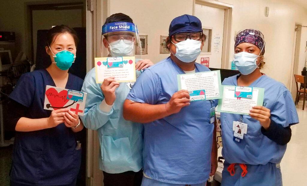 Health care workers hold thank-you cards from the "Cards 4 COVID Heroes" initiative at Los Angeles Community Hospital in Los Angeles on June 30, 2020. (Keith Levy via AP)