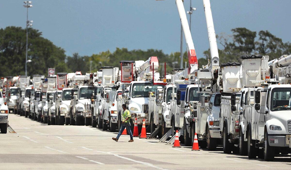 Dozens of utility trucks are lined up to be processed by Florida Power & Light at Daytona International Speedway, Fla., on Aug. 1, 2020. (Stephen M. Dowell/Orlando Sentinel)