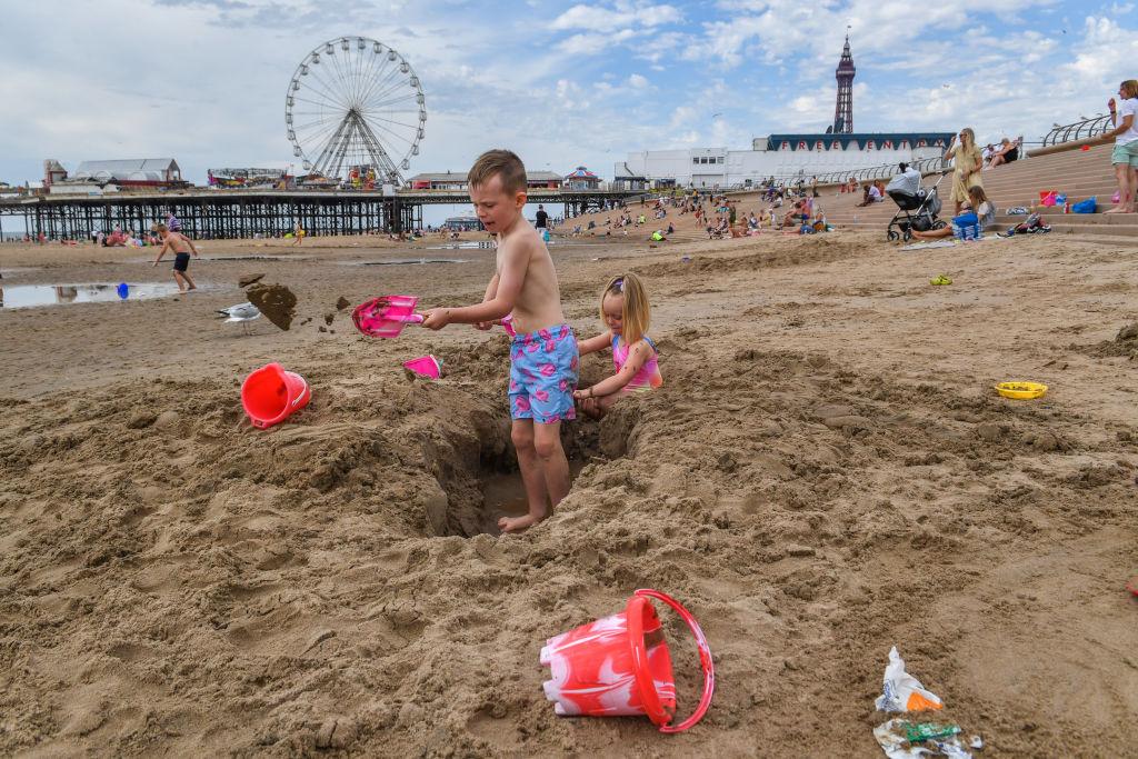 Children build sandcastles on Blackpool Beach in Blackpool, England, on July 31, 2020. (Anthony Devlin/Getty Images)