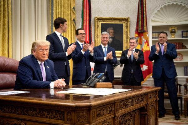 (L–R, rear) Senior adviser Jared Kushner, Secretary of the Treasury Steven Mnuchin, national security adviser Robert O'Brien and others clap for President Donald Trump (L) after he announced an agreement between the United Arab Emirates and Israel to normalize diplomatic ties, at the White House on Aug. 13, 2020. (Brendan Smialowski/AFP via Getty Images)