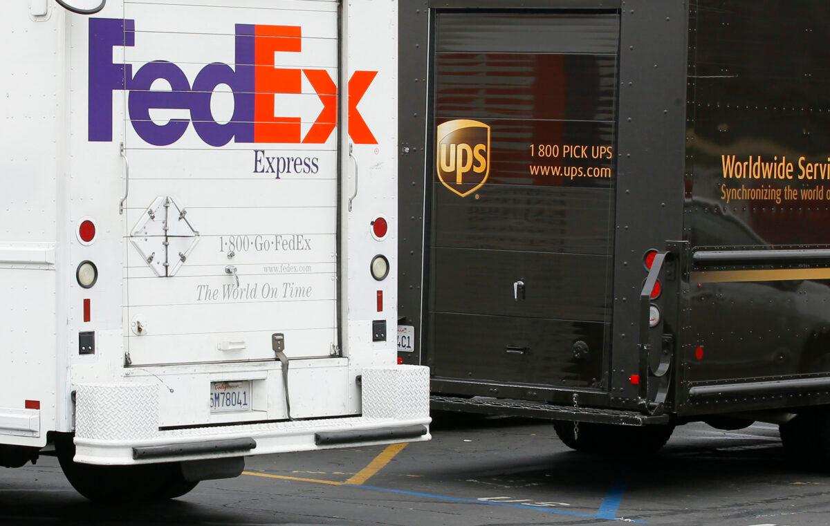 A FedEx truck is parked next to a UPS truck as both drivers make deliveries in San Diego, Cali., on March 5, 2013. (Mike Blake/Reuters)