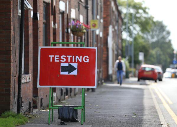 A sign shows traffic where to turn to enter a CCP virus testing centre in Oldham, England, on Aug. 20, 2020. (Lindsey Parnaby/AFP via Getty Images)