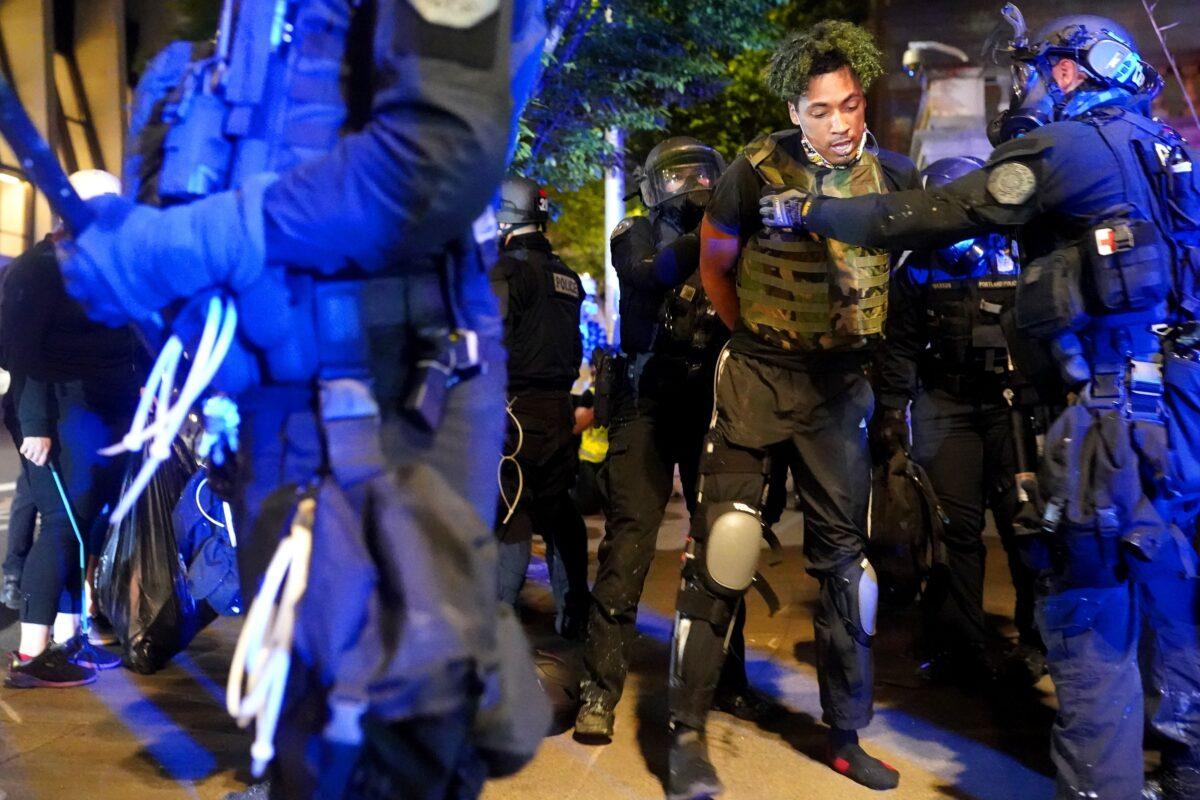 Portland police officers arrest a man amid rioting Portland, Ore., late Aug. 25, 2020. (Nathan Howard/Getty Images)