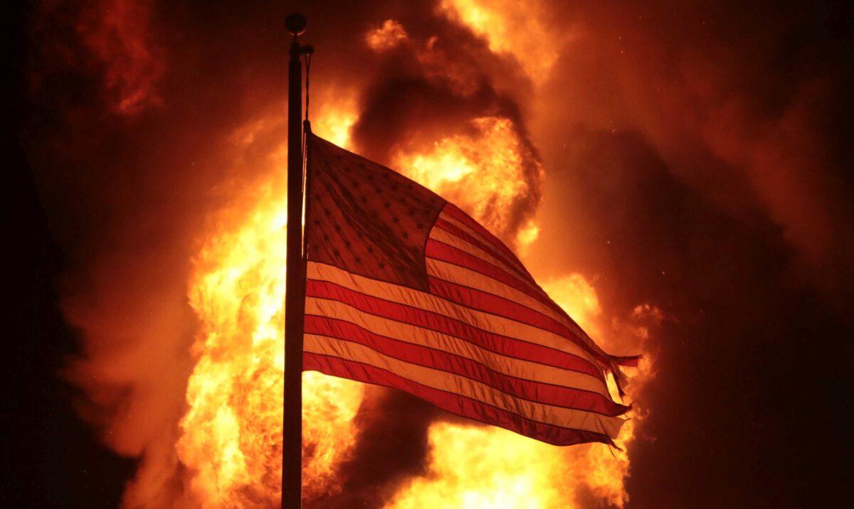 An American flag flies in front of a department of corrections building after it was set ablaze during a second night of rioting in Kenosha, Wis., on Aug. 24, 2020. (Scott Olson/Getty Images)