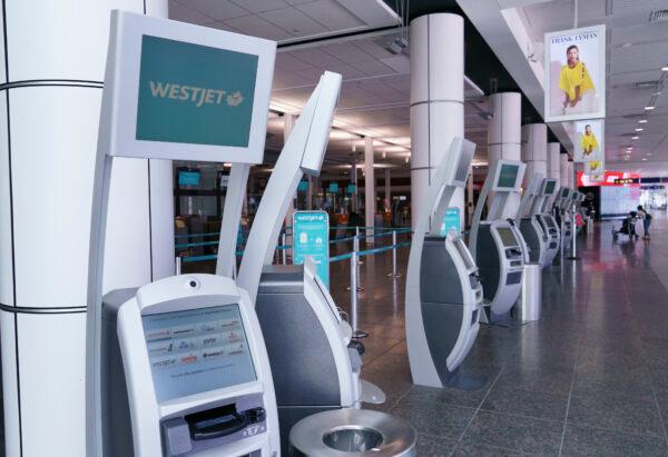 WestJet self service check-in kiosks are seen at Montreal-Trudeau International Airport in Montreal, on July 31, 2020. (Paul Chiasson/The Canadian Press)