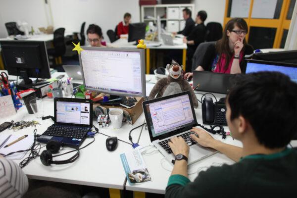 In this file photo, people work at computers in TechHub, a busy office space for technology start-up entrepreneurs near the Old Street roundabout in Shoreditch, London, on Mar. 15, 2011. (Oli Scarff/Getty Images)