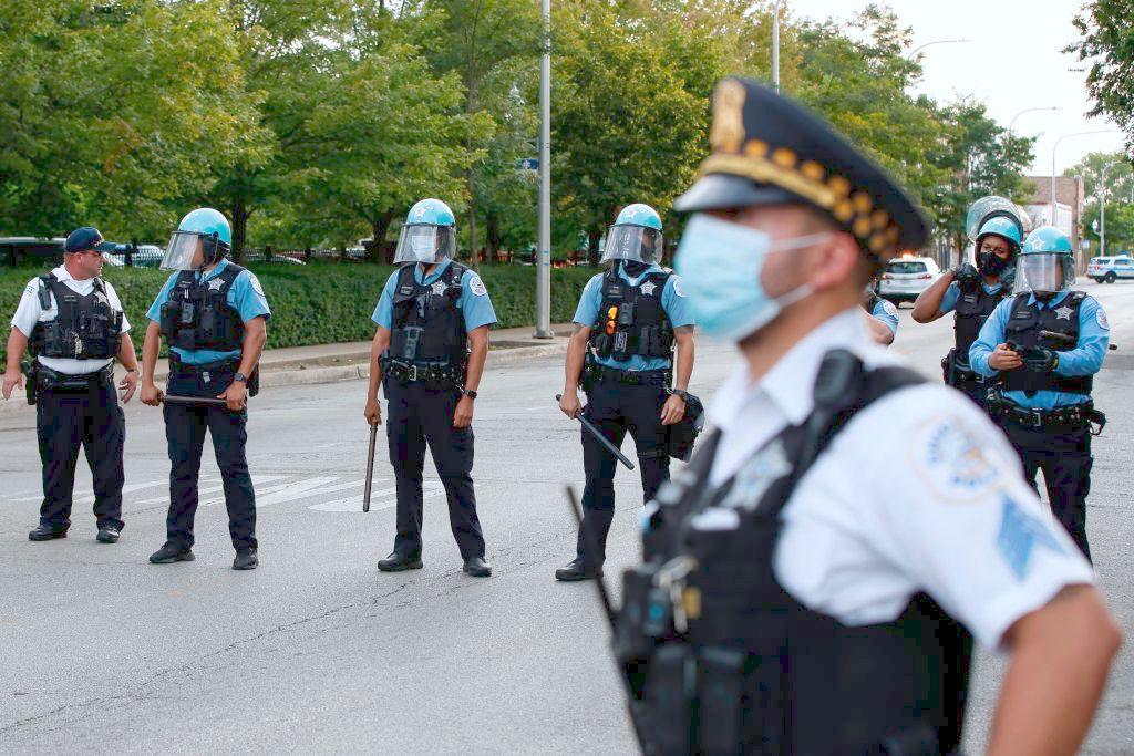 Chicago Police officers guard the area outside their District 7 headquarters during a rally against Chicago Police violence in the Englewood neighborhood in Chicago, Illinois, on August 11, 2020. (Kamil Krzaczynski/AFP via Getty Images)