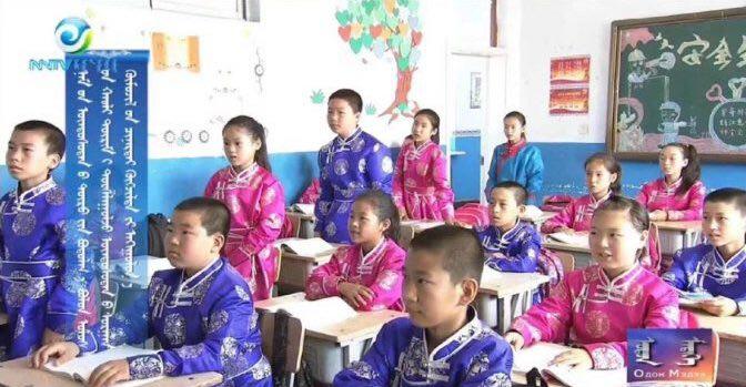 State media show students dressed in traditional attire appear in the classroom of a primary school in Inner Mongolia, which locals said was staged. (Screenshot)