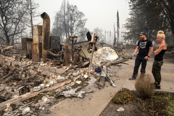 Derek Trenton and Shawna Haptonstall look at the ruins of Derek's parents home as wildfires devastate the region, in Talent, Ore., on Friday, Sept. 11, 2020. (Paula Bronstein/AP Photo)