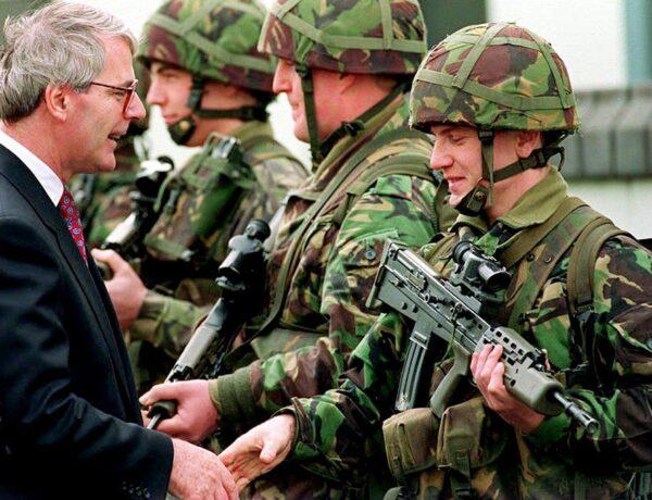 Then British Prime Minister John Major shakes hands with security personnel on duty in the Ennskillen area of Northern Ireland on 31 Mar. 1994. (PA/AFP via Getty Images)