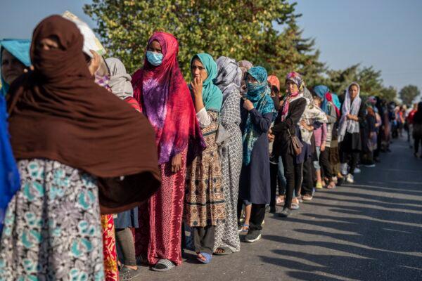 Migrants wait in a queue for food distribution near Mytilene town, on the northeastern island of Lesbos, Greece, on Sept. 12, 2020. (Petros Giannakouris/AP Photo)