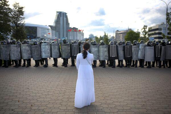 A woman wearing white stands in front of a riot police line during an opposition rally in Minsk, on Sept. 13, 2020. (TUT.by via AP)