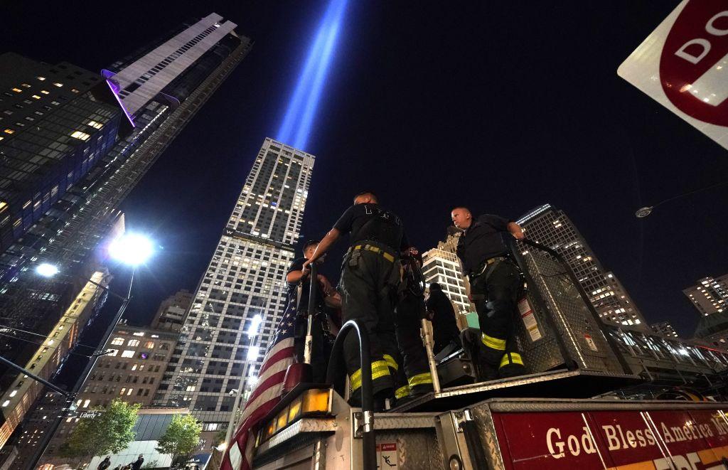 New York firefighters stand on their truck outside the 9/11 Memorial as the Tribute in Light beams over Manhattan on Sept. 11, 2020 (TIMOTHY A. CLARY/AFP via Getty Images)