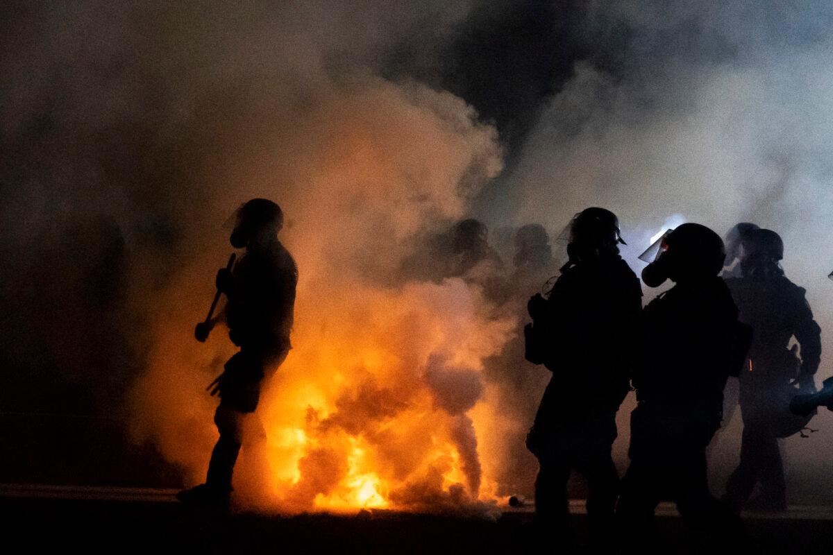 Oregon State Troopers and Portland police advance through tear gas while confronting rioters in Portland, Ore., on Sept. 5, 2020. (Nathan Howard/Getty Images)
