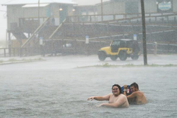 People play in a flooded parking lot at Navarre Beach on Sept. 15, 2020, in Pensacola Beach, Fla. (Gerald Herbert/AP Photo)