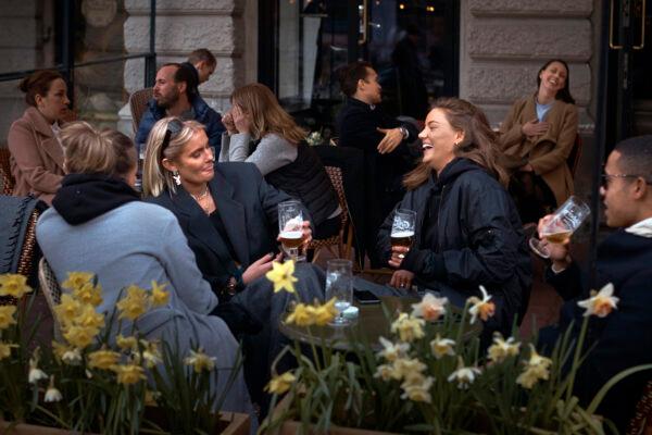 People chat and drink outside a bar in Stockholm, on April 8, 2020. (Andres Kudacki/AP Photo)