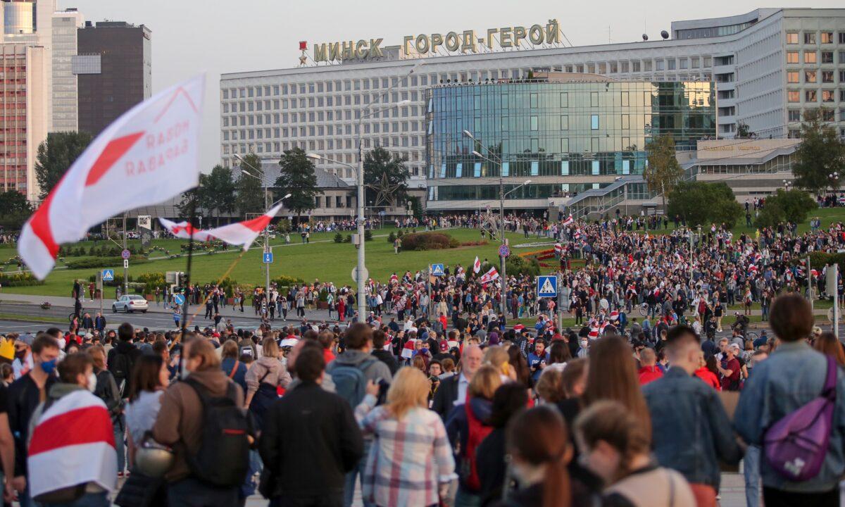 People with old Belarusian national flags gather during an opposition rally to protest the presidential inauguration in Minsk, Belarus, on Sept. 23, 2020. (TUT.by via AP Photo)