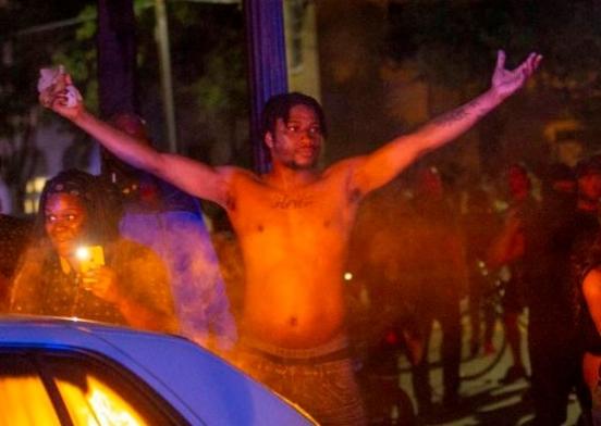 Kelsey Jackson, who pleaded guilty to arson of a Charleston Police Department cruiser, raises his arms during a riot in Charleston, S.C., May 30, 2020. (Department of Justice)