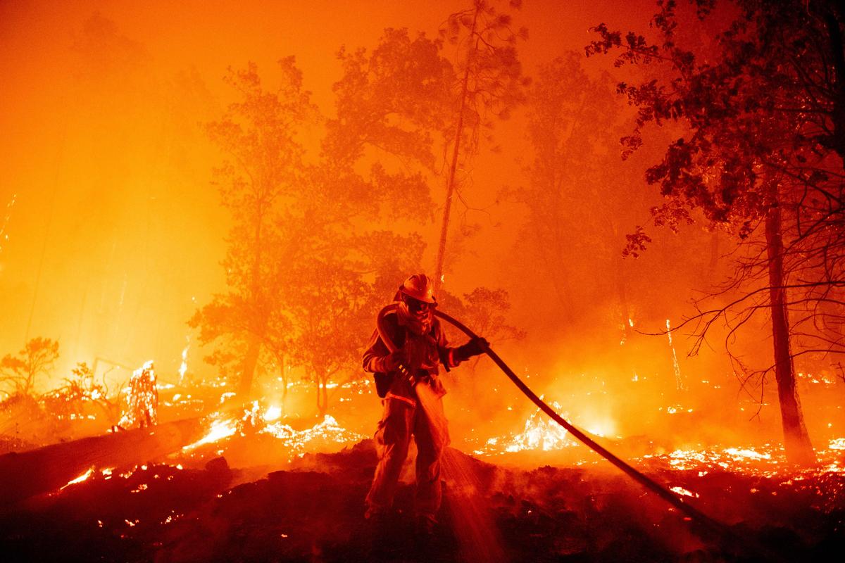 A firefighter douses flames as they push towards homes during the Creek Fire in the Cascadel Woods area of unincorporated Madera County, California, on Sept. 7, 2020. (JOSH EDELSON/AFP via Getty Images)