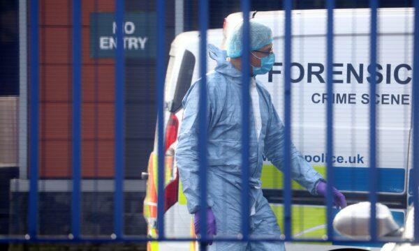 A forensic specialist is seen at the custody center where a British police officer has been shot dead in Croydon, south London, on Sept. 25, 2020. (Hannah McKay/Reuters)