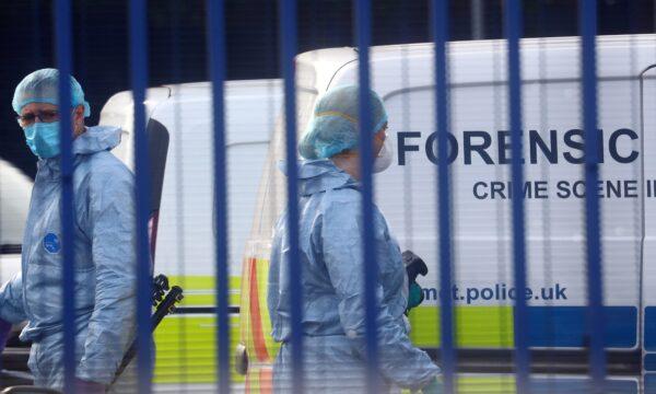 Forensic specialists are seen at the custody center where a British police officer has been shot dead in Croydon, south London, on Sept. 25, 2020. (Hannah McKay/Reuters)