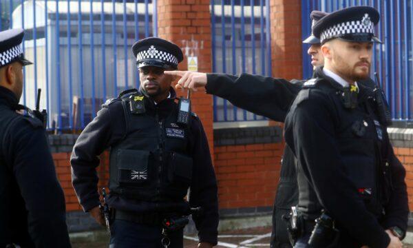 Policemen gather outside the custody center where a British police officer has been shot dead in Croydon, south London, on Sept. 25, 2020. (Hannah McKay/Reuters)