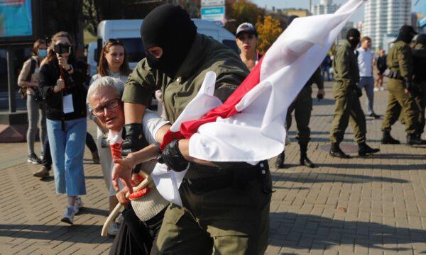 A Belarusian law enforcement officer detains activist Nina Baginskaya during an opposition rally to reject the presidential election results and to protest against the inauguration of President Alexander Lukashenko in Minsk, on Sept. 26, 2020. (Stringer/Reuters)
