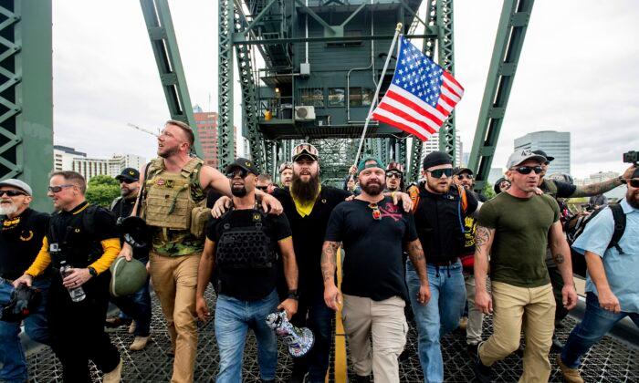Members of the Proud Boys and Chairman Enrique Tarrio, holding a megaphone, along with other demonstrators march across the Hawthorne Bridge during a rally in Portland, Ore., on Aug. 17, 2019. (Noah Berger/AP Photo)