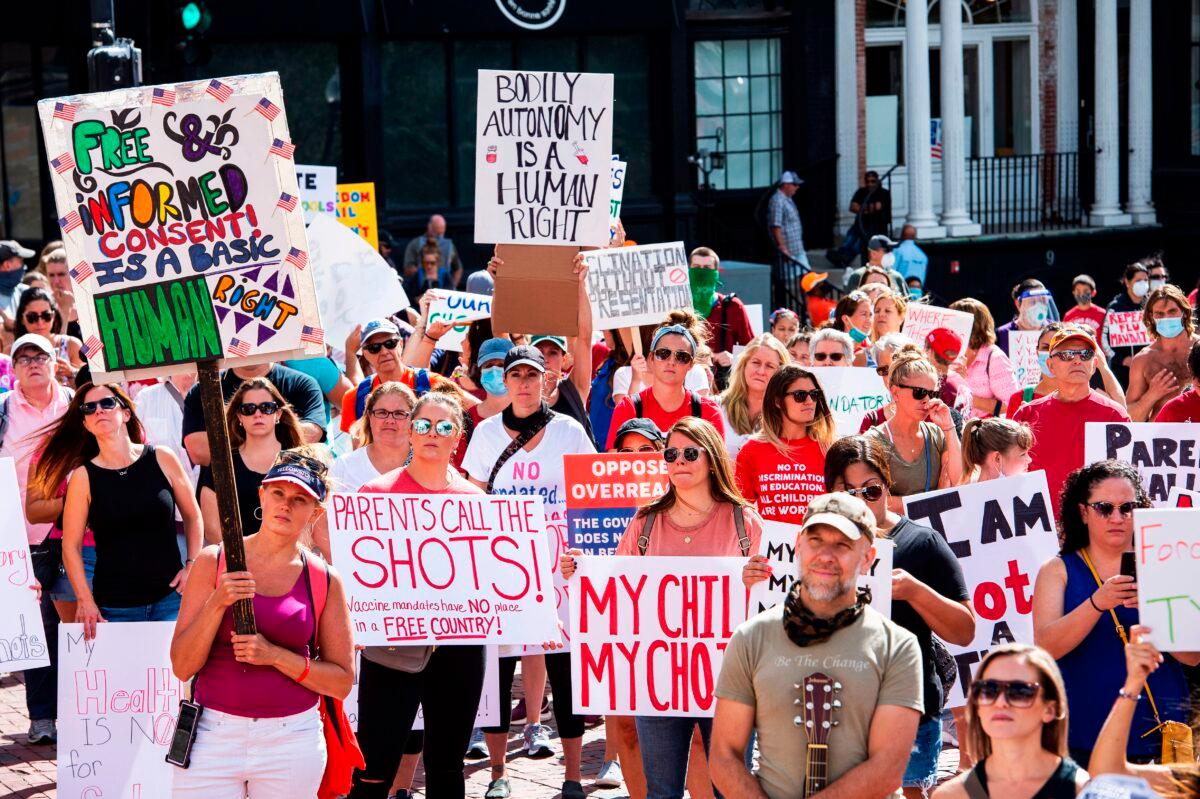 Hundreds of people of mixed political views, religions, and cultures protest a mandate from the Massachusetts Governor requiring all children, age K-12, to receive an influenza (flu) vaccine/shot to attend school for the 2020/2021 year outside the Massachusetts State House in Boston on Aug. 30, 2020. (Joseph Prezioso /AFP via Getty Images)