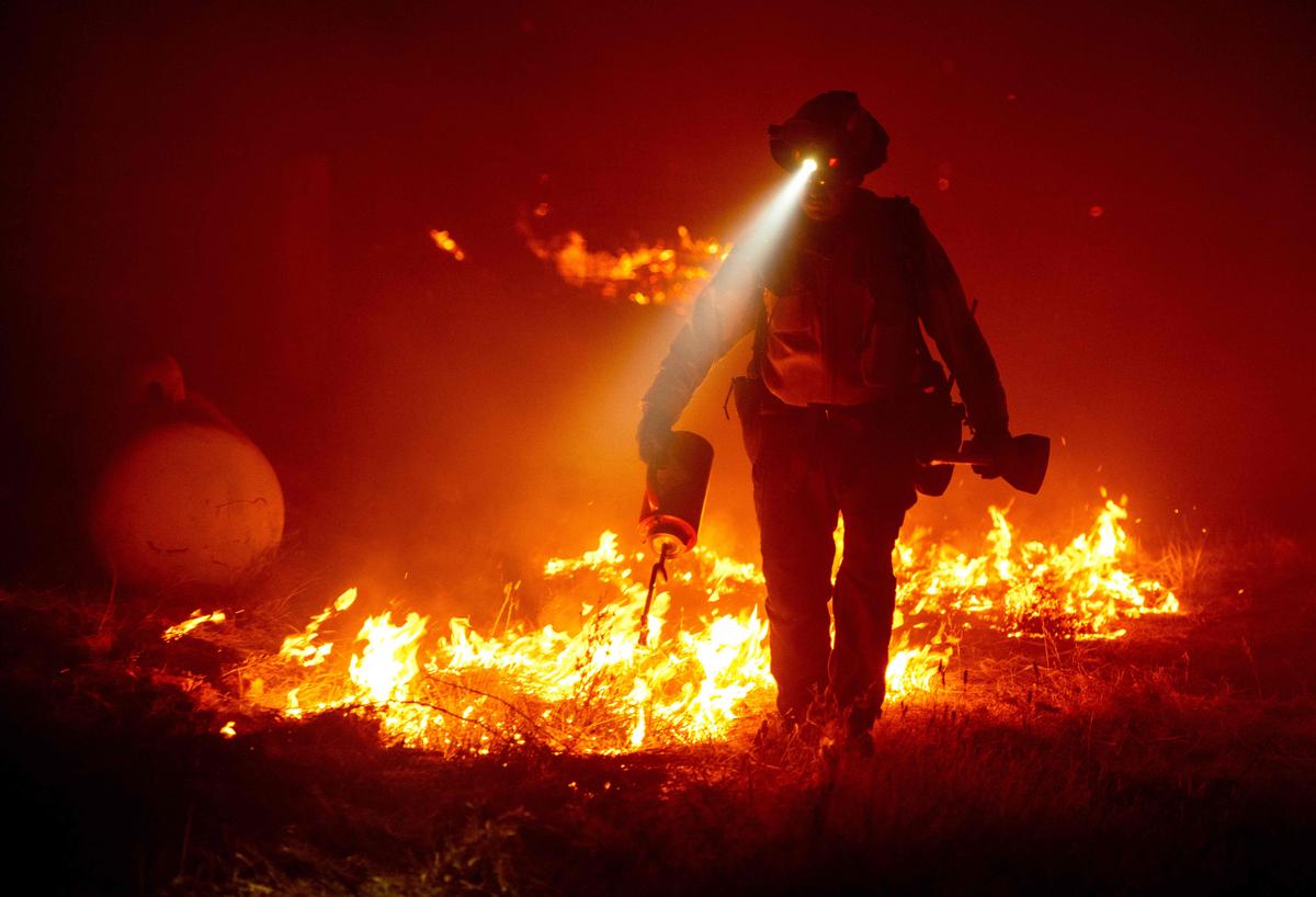 Firefighters light backfires to protect structures behind a CalFire fire station during the Bear Fire in the Berry Creek area of Butte County, California, on Sept. 9, 2020 (JOSH EDELSON/AFP via Getty Images)