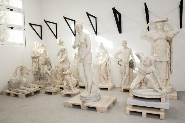 A group of restored sculptures: In the front row, a statue of a kneeling warrior is next to a statue of Aphrodite, a replica of the Venus de' Medici. Torlonia Collection. (Lorenzo De Masi/Torlonia Foundation)