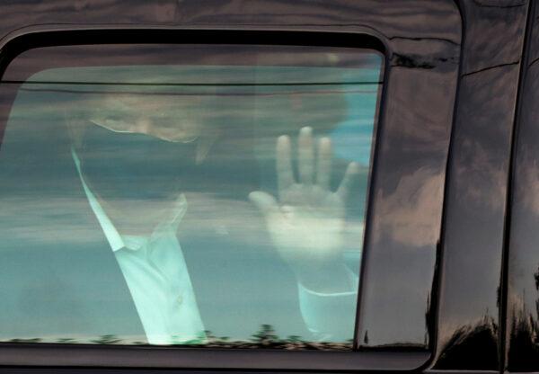President Donald Trump waves to supporters as he briefly rides by in the presidential motorcade in front of Walter Reed National Military Medical Center, where he is being treated for COVID-19 in Bethesda, Md., Oct. 4, 2020. (Cheriss May/Reuters)