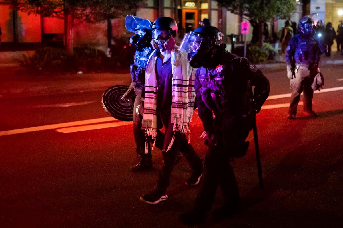 Police arrest a person during a riot, in Portland, Ore., early Oct. 7, 2020. (Nathan Howard/Getty Images)