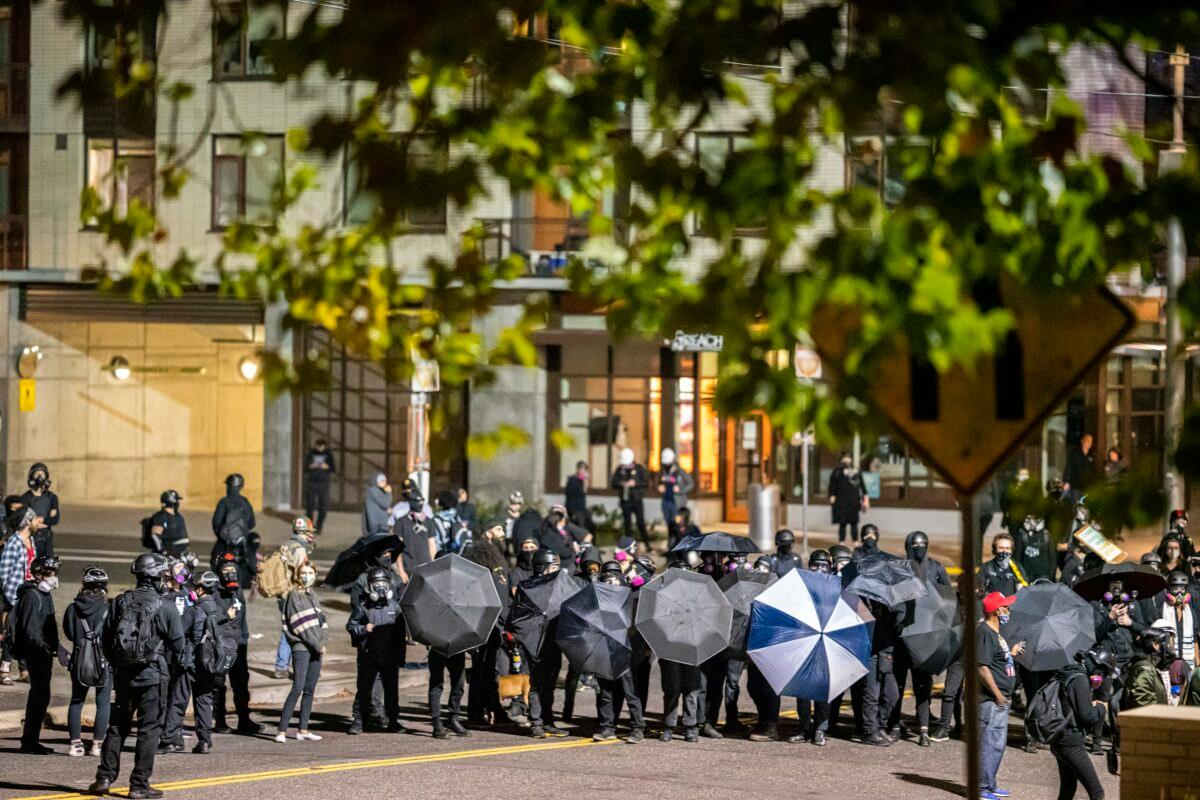 An umbrella line is seen during a gathering in Portland, Ore., late Oct. 6, 2020. (Nathan Howard/Getty Images)