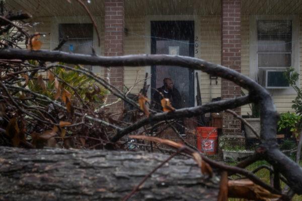 Michael Roberson, 46, is framed by debris from Hurricane Laura, as he watches the arrival of Hurricane Delta from his doorsteps in Lake Charles, Louisiana on Oct. 9, 2020. (Adrees Latif/Reuters)