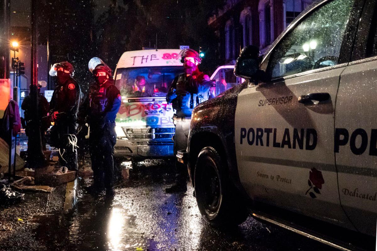 Police detain passengers of a van linked to rioting, in Portland, Ore., on Oct. 11, 2020. (Nathan Howard/Getty Images)