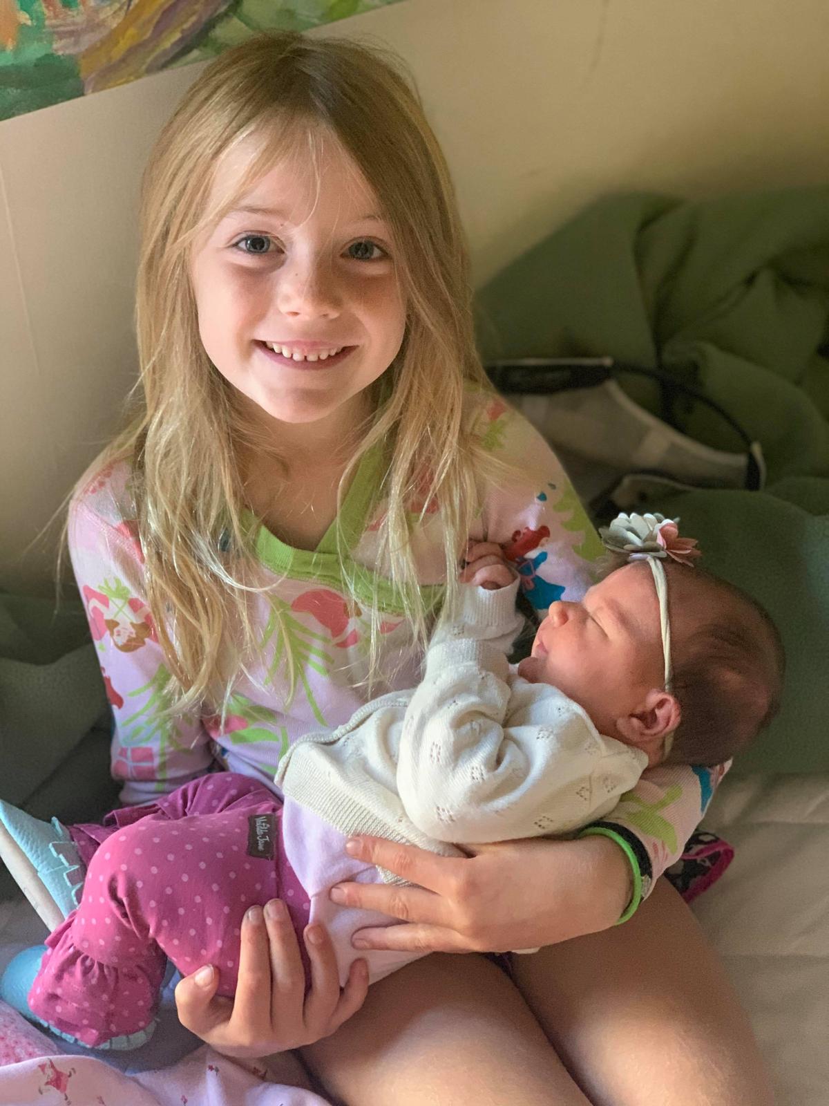 Big sister Zinnia holding baby Azalea (Courtesy ofthe Gray Family)