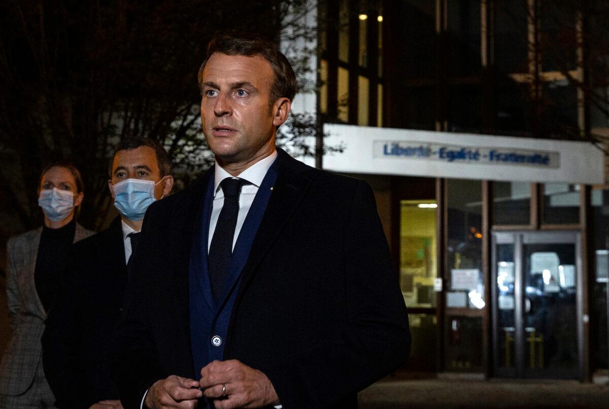 French President Emmanuel Macron, flanked by French Interior Minister Gerald Darmanin, second left, speaks in front of a high school in Conflans Sainte-Honorine, on Oct.16, 2020 (Abdulmonam Eassa, Pool via AP)