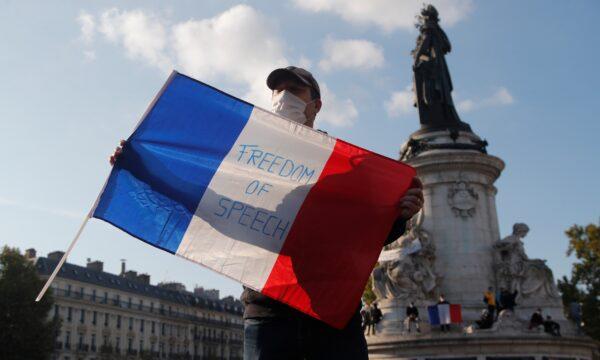 A demonstrator holds a French flag with the slogan "Freedom of Speech" during a demonstration in Paris on Oct. 18, 2020. (Michel Euler/AP Photo)