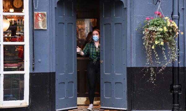 A member of staff closes a door of The Beehive pub in the Grassmarket following last orders at 6 p.m., in Edinburgh, Scotland, on Oct. 9, 2020. (Jeff J Mitchell/Getty Images)