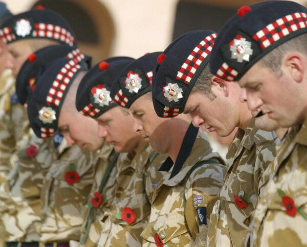 British soldiers observe two minutes of silence at a British war memorial in Iraq, as they mark Remembrance Day for fallen troops on Nov. 9, 2003. (AHMAD AL-RUBAYE/AFP via Getty Images)