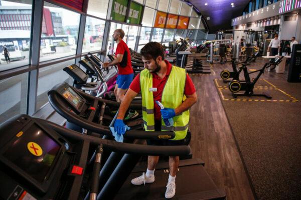 A worker disinfects a treadmill in the gym at London Aquatics Centre in London on July 25, 2020. (Hollie Adams/Getty Images)