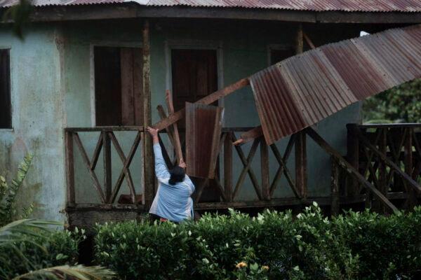 A woman works to recover the part of roof damaged by Hurricane Eta in Wawa, Nicaragua, on Nov. 3, 2020. (Carlos Herrera/AP Photo)