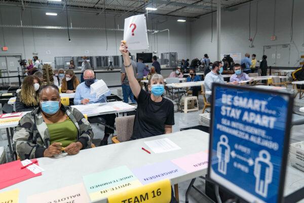 A Gwinnett county worker raises a piece of paper indicating she has a question as the recount of ballots begins in Lawrenceville, Ga., on Nov. 13, 2020. (Megan Varner/Getty Images)